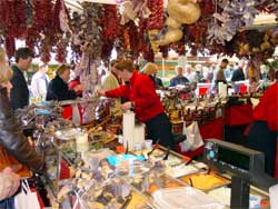 Shoppers at a peppers, olives and garlic stand at the Viktualienmarkt